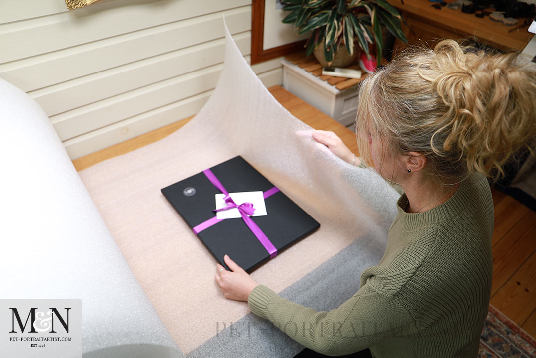 Melanie in the studio packing a pet portrait 